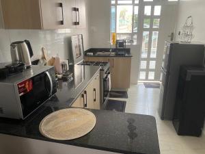 a kitchen with a counter top with a microwave at Urbanza Haven Nakuru in Nakuru