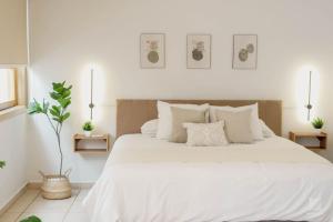 a bedroom with a large white bed with three pictures on the wall at AR Suites Casa Master Suite Nueva Luneta in Zamora de Hidalgo