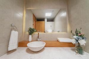 a bathroom with a large white bowl sink and a tub at AR Suites Casa Master Suite Nueva Luneta in Zamora de Hidalgo