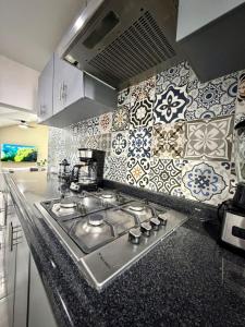 a kitchen with a stove top with tiles on the wall at AR Suites 1 Centro de la ciudad in Zamora de Hidalgo