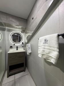 a bathroom with a sink and a mirror and a towel at AR Suites 1 Centro de la ciudad in Zamora de Hidalgo