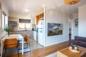 a kitchen and living room with a table and a couch at Stunning Water Views 2 in Jindabyne