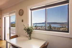 a dining room with a table and a large window at Stunning Water Views 2 in Jindabyne