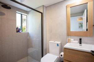 a bathroom with a toilet and a sink and a shower at Stunning Water Views 2 in Jindabyne +18 photos
