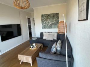 a living room with a blue couch and a table at Stunning Water Views 2 in Jindabyne