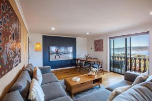 a living room with a couch and a table at Stunning Water Views 3 in Jindabyne