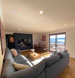 a living room with a large couch and a table at Stunning Water Views 3 in Jindabyne