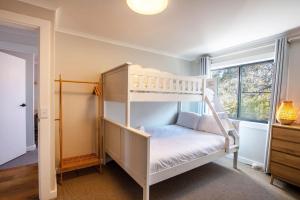 a bedroom with a bunk bed and a window at Stunning Water Views 3 in Jindabyne