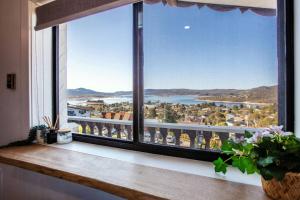 a room with a window with a view of the water at Stunning Water Views 3 in Jindabyne