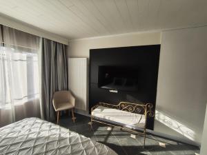 a bedroom with a bed and a tv on a wall at Lazy Olives in Tongeren