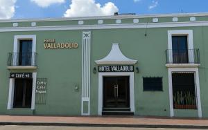 a green building with a sign on the front of it at Hotel Valladolid in Valladolid