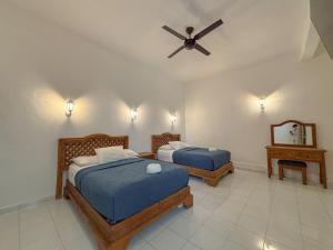 a bedroom with two beds and a ceiling fan at Hotel Valladolid in Valladolid