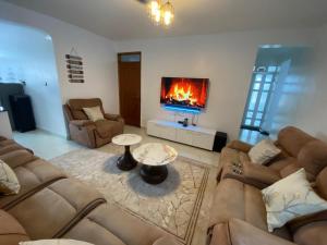 a living room with two couches and a fireplace at Urbanza Haven Nakuru in Nakuru