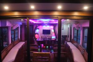 a view of a room with chairs and a tv at Sacred River Houseboats in Alleppey