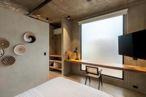 a bedroom with a desk and a large window at The Sunset Deck in Jacó
