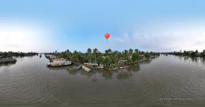 a red balloon flying over a river with boats at Sacred River Houseboats in Alleppey +3 photos