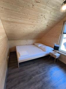 ein Schlafzimmer mit einem Bett in einem Holzzimmer in der Unterkunft Cicha Przystań Skępe 300 m od jeziora in Skępe + 13 Fotos