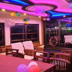a restaurant with a table and chairs and purple lighting at Sacred River Houseboats in Alleppey