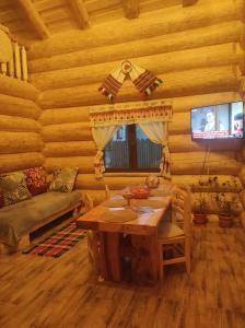 a living room with a table in a log cabin at Rustic House in Predeal