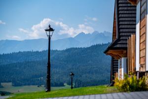 a street light on a hill with mountains in the background at Osada Dursztyn- Przystanek Podhale in Białka Tatrzańska