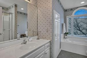 a white bathroom with a sink and a tub and a tubermott at Lakefront Retreat-Sunset Views in Prosperity +39 photos