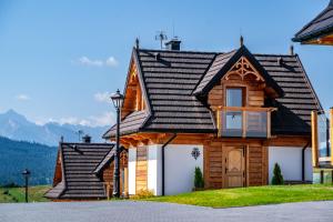 a wooden house with a black roof at Osada Dursztyn- Przystanek Podhale in Białka Tatrzańska