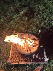a fire in a wooden plate on the grass at Happy Meadows - Mushroom Street in Long Stratton