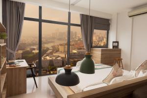 a bedroom with a bed with a view of a city at The Snowbell Hotel & Spa at The Bridge in Phnom Penh +32 photos