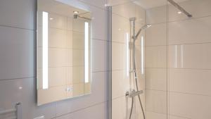 ein Badezimmer mit Dusche und Spiegel in der Unterkunft Hotel Eperland in Epen + 65 Fotos