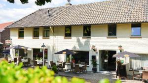 ein Restaurant mit Tischen und Stühlen vor einem Gebäude in der Unterkunft Hotel Eperland in Epen