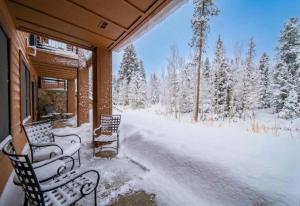 two chairs on a porch covered in snow at Springs 8806 by SummitCove Lodging in Colorado in Keystone +56 photos