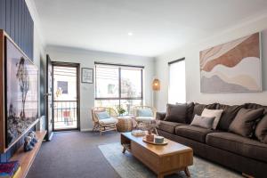 a living room with a couch and a table at Mountain Oak 2 Jindabyne in Jindabyne