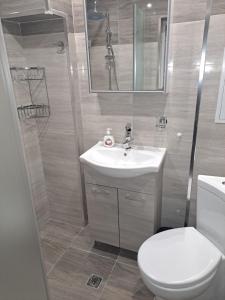 a bathroom with a toilet and a sink and a shower at Удобство - 3 in Petrich