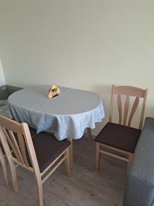 a table with a white table cloth and two chairs at Удобство - 3 in Petrich