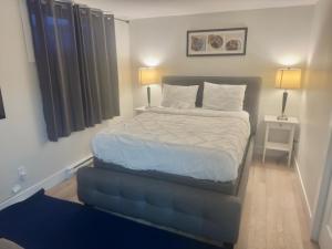 a large bed in a bedroom with two lamps at Airport Getaway- 4 mins from Airport in Dieppe