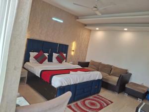 a bedroom with a large bed and a couch at Hotel Royal Stay in Gurgaon