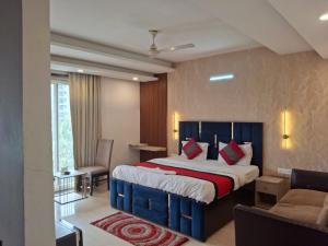 a bedroom with a bed and a couch and a chair at Hotel Royal Stay in Gurgaon