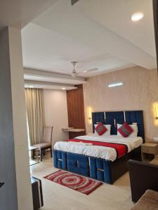 a hotel room with a large bed and a chair at Hotel Royal Stay in Gurgaon +3 photos