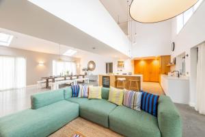 a living room with a green couch and a kitchen at Seahenge in Brancaster