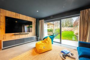 a living room with a large television and a blue couch at Seahenge in Brancaster
