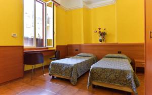 zwei Betten in einem Zimmer mit gelben Wänden in der Unterkunft Ogbay Backpackers Haven in Rom + 2 Fotos