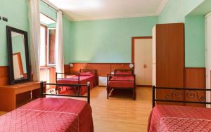 Ein Zimmer mit drei Betten, bezogen mit roter Bettwäsche und mit grünen Wänden in der Unterkunft Ogbay Backpackers Haven in Rom