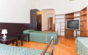 ein Hotelzimmer mit zwei Betten und einem Flachbildfernseher in der Unterkunft Ogbay Backpackers Haven in Rom