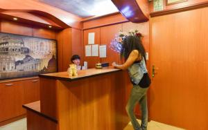 eine Frau steht an einer Bar in einem Hotelzimmer in der Unterkunft Ogbay Backpackers Haven in Rom