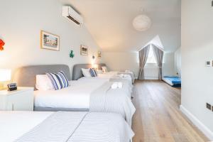 a row of four beds in a room at Seahenge in Brancaster