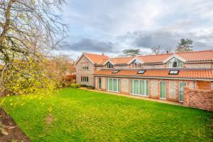 a large brick building with a green yard at Seahenge in Brancaster