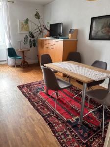 a dining room with a table and chairs on a rug at Vorderer Westen Kassel in Kassel