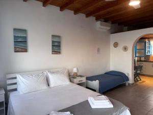 a bedroom with a bed and a desk and a chair at Milos Sea House in Empourios