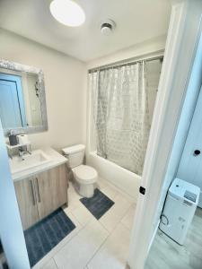 a bathroom with a toilet and a sink and a shower at Airport Getaway- 4 mins from Airport in Dieppe