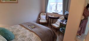 a bedroom with a bed and a desk and chairs at Chez Jo in Lewes